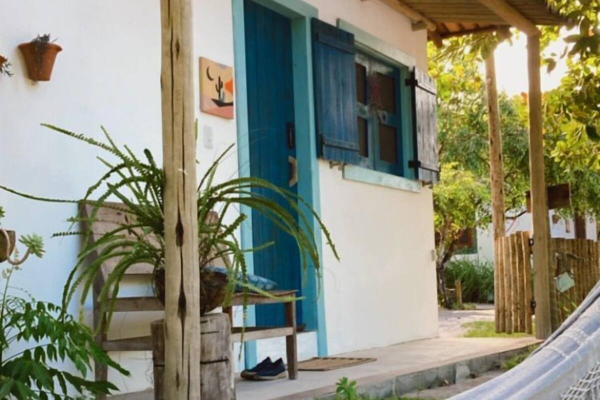 A house with a blue door and a hammock in front.