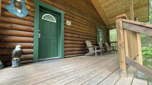 A wooden cabin with a green door, a wooden porch, and two Adirondack chairs. - Box Canyon "Eagle's Nest Cabin" - 1 bed, WIFI (Seward)