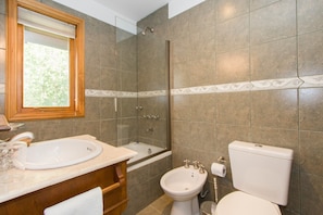 Un baño con bañera, bidé, inodoro y lavamanos.
