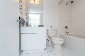 Bathroom features a white vanity, toilet with bidet, and bathtub with showerhead.