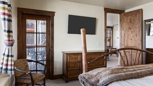 A bedroom with a wooden bed frame, a wooden dresser, a chair, and a large mirror. - Outpost: Grand View 5020A - Fireplace, Elevator, AC! (Jackson)