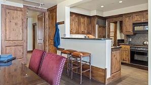 A modern kitchen with wooden cabinets, a central island, and stainless steel appliances. - Outpost: Grand View 5020A - Fireplace, Elevator, AC! (Jackson)