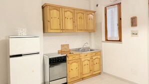 A kitchen with wooden cabinets, a stainless steel sink, and a built-in oven. - M333 - Marcelli, cozy two-room apartment 200 meters from the beach (Marcelli)
