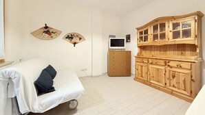 A room with a bed, a wooden cabinet, a television, and two wall-mounted fans. - M333 - Marcelli, cozy two-room apartment 200 meters from the beach (Marcelli)