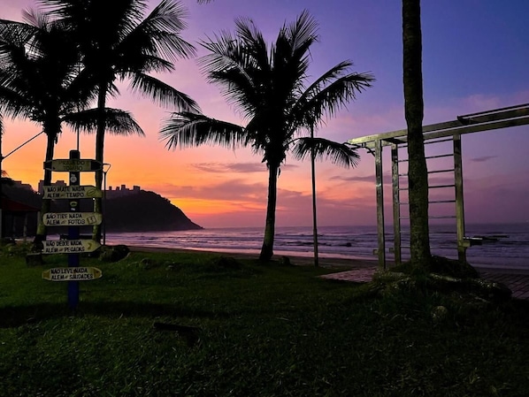 Apartamento | Praia | Na praia, areia branca, guarda-sóis, prática de vôlei de praia