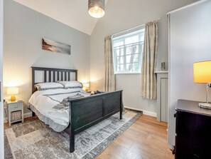 A bedroom with a bed, bedside lamps, a window with curtains, a wall-mounted artwork, and a bedside table with a lamp. - 1 bedroom accommodation in Heathfield (Heathfield)
