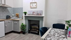 Una cucina moderna con mobili grigi, un piano di lavoro bianco e una parete di mosaico grigia.