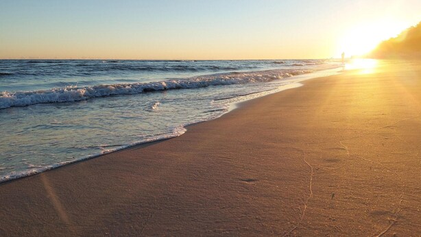A beach with waves at sunset. - 1 bedroom awesome apartment in Gdynia (Gdynia)
