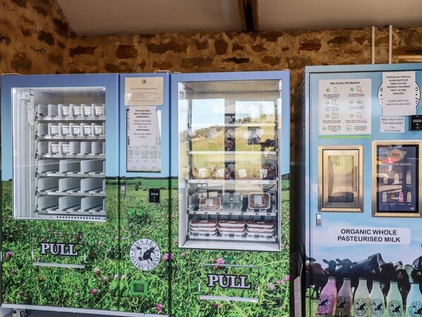 Máquina expendedora de leche con varios compartimentos para distintos productos.