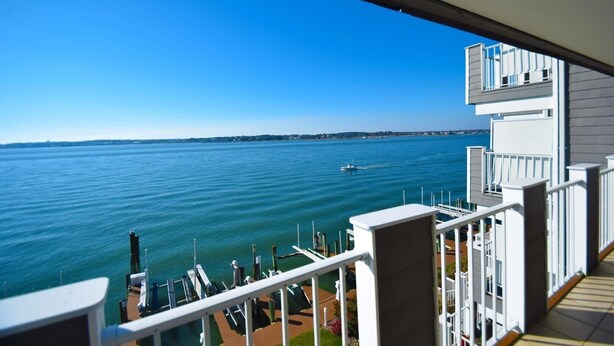 A balcony with a view of the sea and a distant shoreline.
