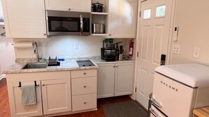 A compact kitchen with white cabinets, a microwave, a stove, and a refrigerator. - Lux Studio W Kitchenette Pets are allowed (Beaufort)