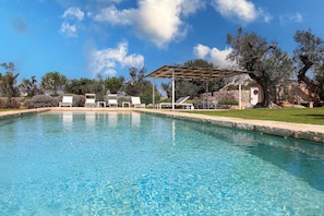 A clear blue pool with lounge chairs and a pergola. - 3194 Masseria Il Carrubo by Perle di Puglia (Salve)