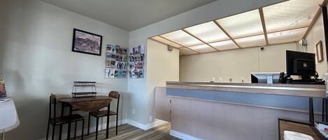 Una cocina pequeña y moderna con una mesa y sillas de madera, una encimera empotrada y una lámpara en el techo.