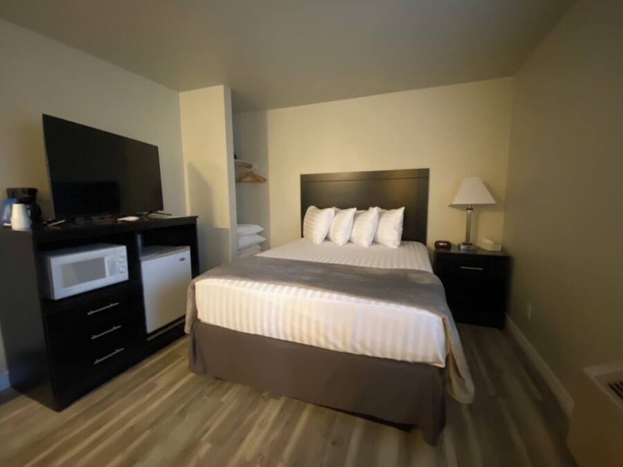 Habitación de hotel con cama, televisor, microondas y escritorio.