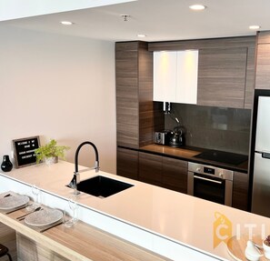 Una cucina moderna con frigorifero in acciaio inox, forno integrato e lavello.