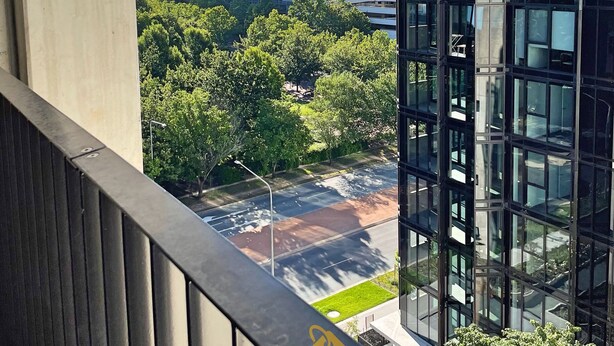 A balcony with a view of modern buildings, a tower, and a green park area. - Splendid 2bd 1bth 1csp Apt - Superb CBD Location (Reid)