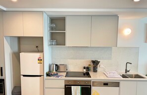 Una cocina compacta equipada con refrigerador, tostadora, horno y pileta.