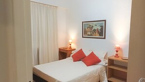 A bedroom with a bed, two bedside tables with lamps, a painting on the wall, and a window with curtains. - Buenos Aires Recoleta, Super apartment 5 people! (Buenos Aires)