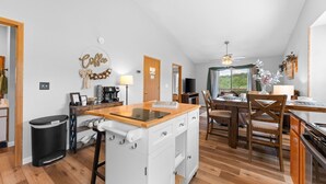 A modern kitchen with a central island, wooden flooring, and a view of the outdoors. - Next to Silver Dollar City - Lakeside Condo (Branson)