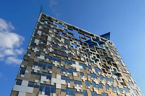 A modern building with a geometric facade and a prominent star-like feature at the top. - Lovely City Break at the Lux City 1bed Apartment (Birmingham)