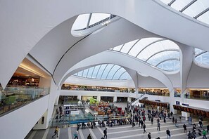 A modern multi-level shopping mall with a glass ceiling and open spaces. - Lovely City Break at the Lux City 1bed Apartment (Birmingham)