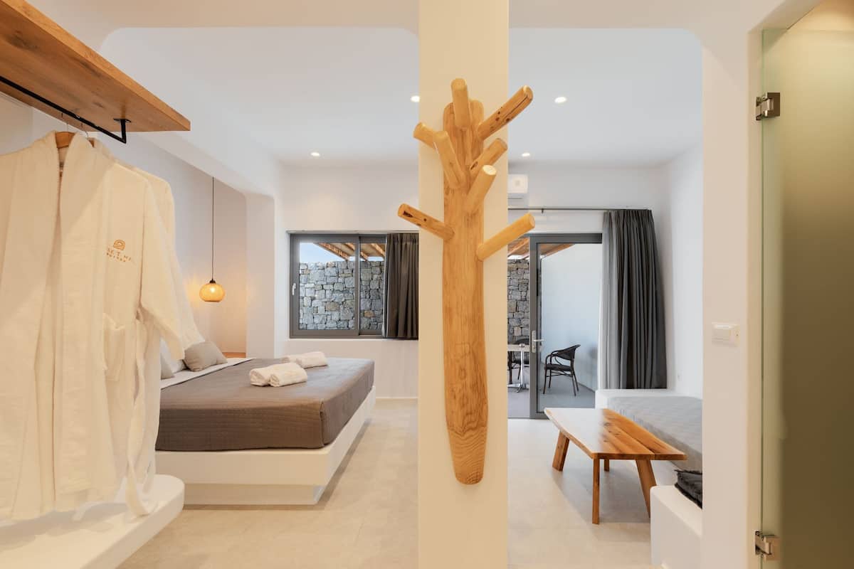A modern bedroom with a bed, bedside table, and a wooden decor piece.