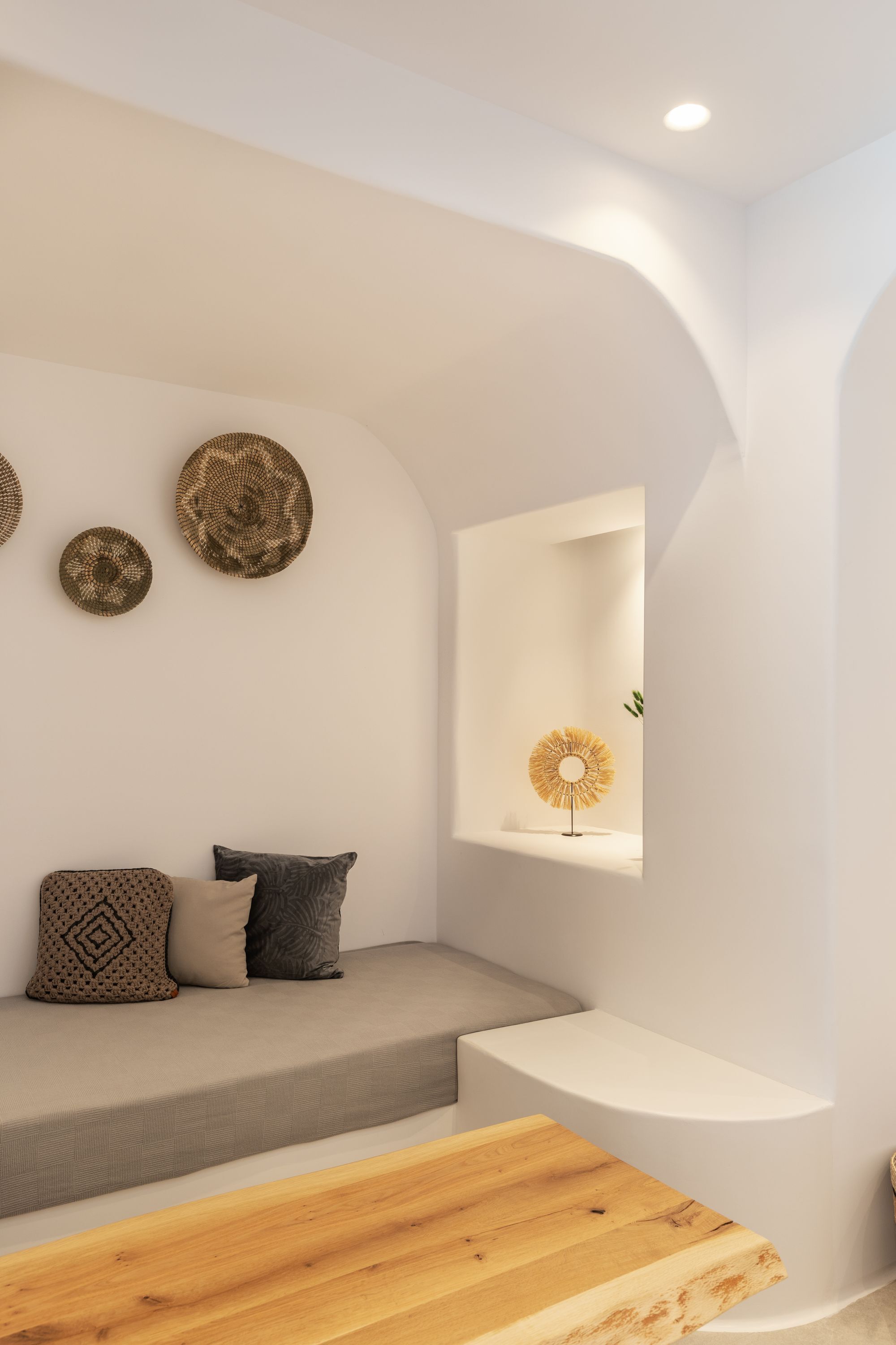 A modern interior with a built-in bench, a wooden table, and decorative wall art.