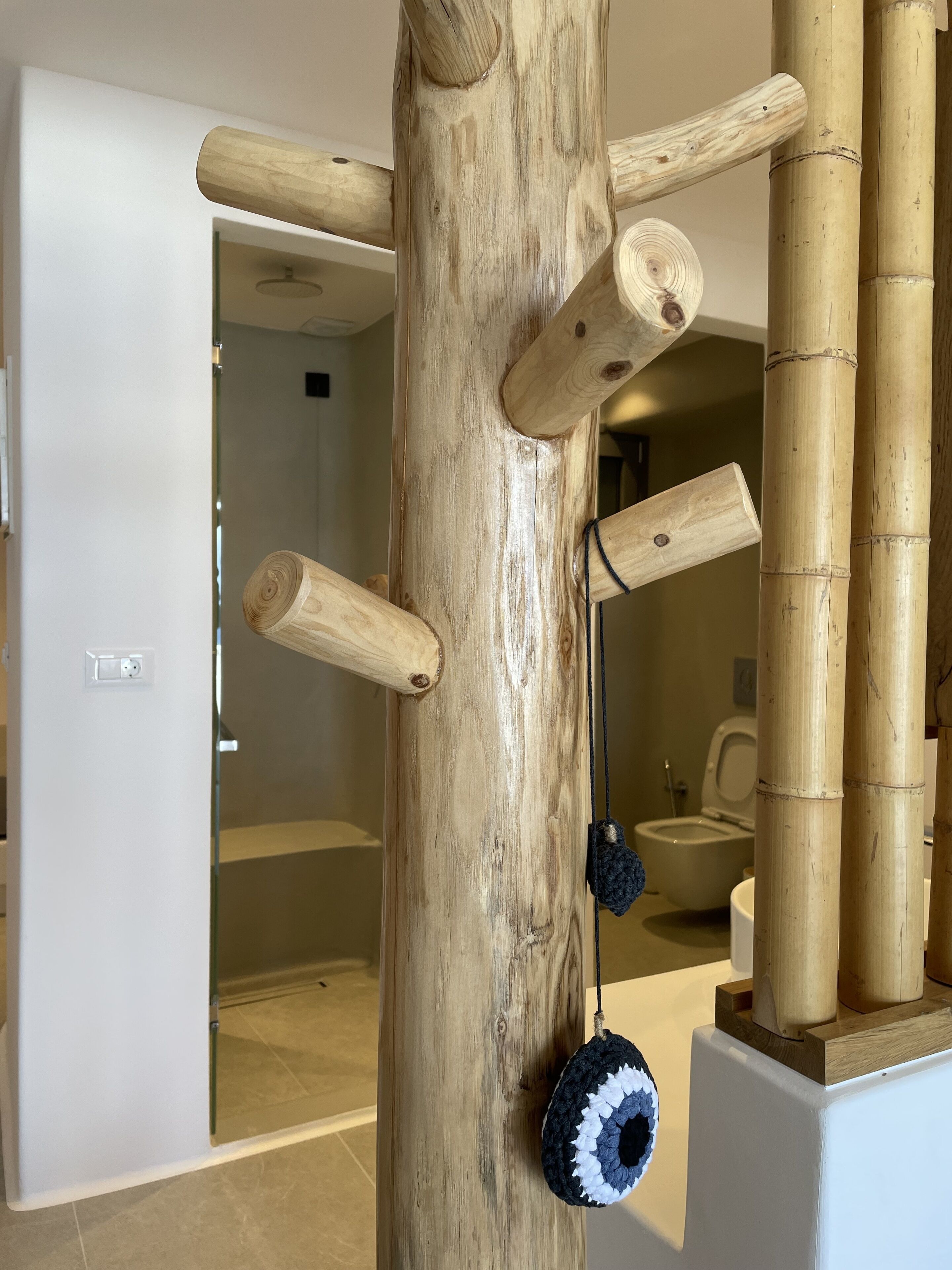 A room with a large wooden structure, possibly a climbing frame, and a bathroom visible through an open door.