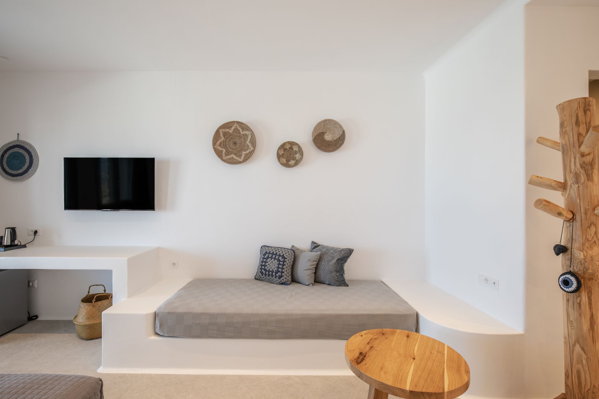 Una sala de estar moderna con un sofá, un televisor y decoración mural.