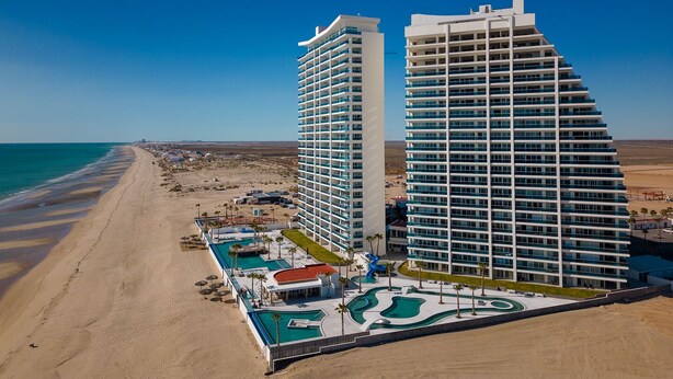 Un hotel moderno con area piscina e accesso diretto alla spiaggia.