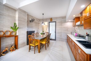 Cozinha moderna com mesa de jantar, armários de madeira e forno embutido.