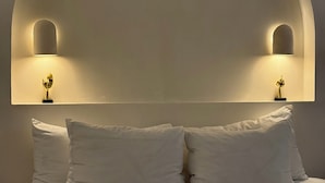 Un dormitorio con una cama grande, dos lámparas de noche y un diseño de techo abovedado único.