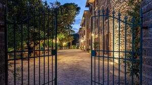Uma entrada fechada para um edifício, com um caminho de pedras que leva a um pátio.