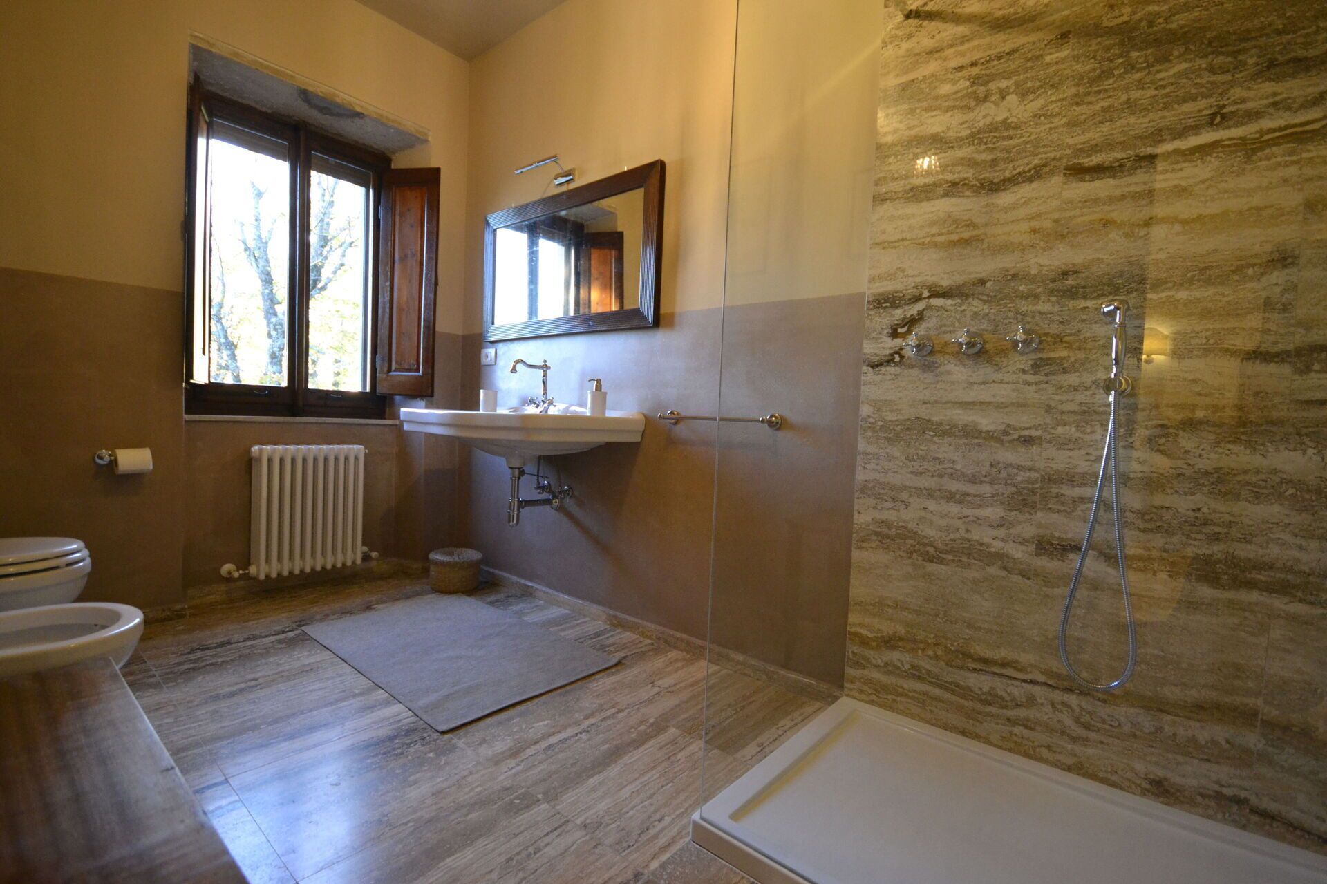 A bathroom with a bathtub, a sink, a toilet, and a window.