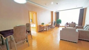 Un amplio salón con mesa de comedor, sillas, sofás y un gran ventanal que proporciona luz natural.