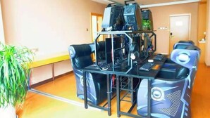 Habitación con una configuración de juegos que incluye un escritorio, sillas y múltiples monitores.