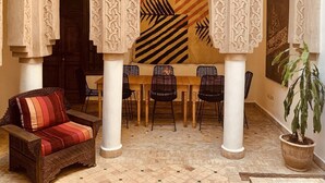 An interior with a dining area, a sofa, and a potted plant. - Riad Laksiba (Marrakech)