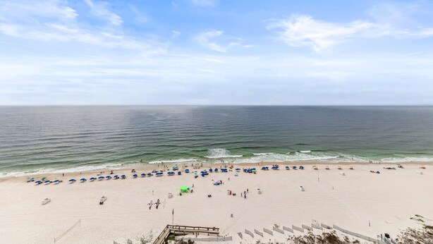 Ein Strand mit Sonnenschirmen und Menschen.