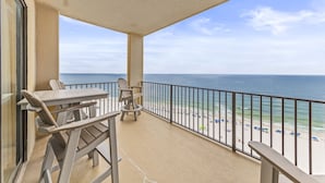 Ein Balkon mit Blick auf Strand und Meer.