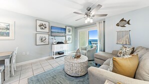 A living room with a ceiling fan, a round coffee table, and a sofa.