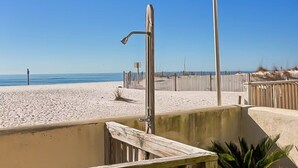 A beach view with a wooden fence, a metal structure, and a clear sky.