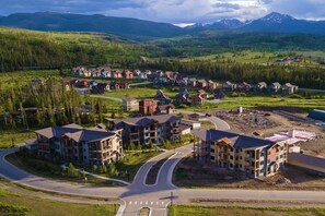 Un quartier résidentiel composé de plusieurs maisons à deux étages, avec un rond-point et un paysage montagneux en arrière-plan.