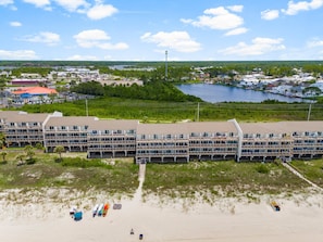 Ein großes Hotel mit mehreren Etagen und Balkonen, gelegen in Strandnähe und an einem Gewässer.