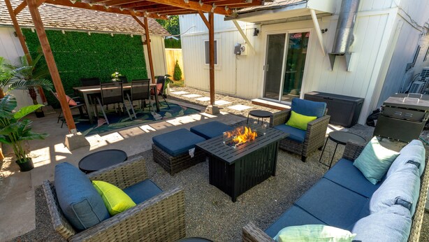 An outdoor patio with wicker furniture, a fire pit, and a grill area. - 5 Bedroom Home Downtown, Close to shops! (Chelan)