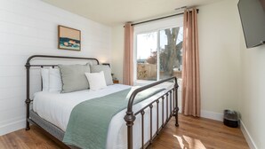 A bedroom with a bed, a window with curtains, a picture on the wall, and a ceiling light. - 5 Bedroom Home Downtown, Close to shops! (Chelan)