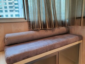 Relax in a cozy seating area with a cushioned bench against a patterned wall.
