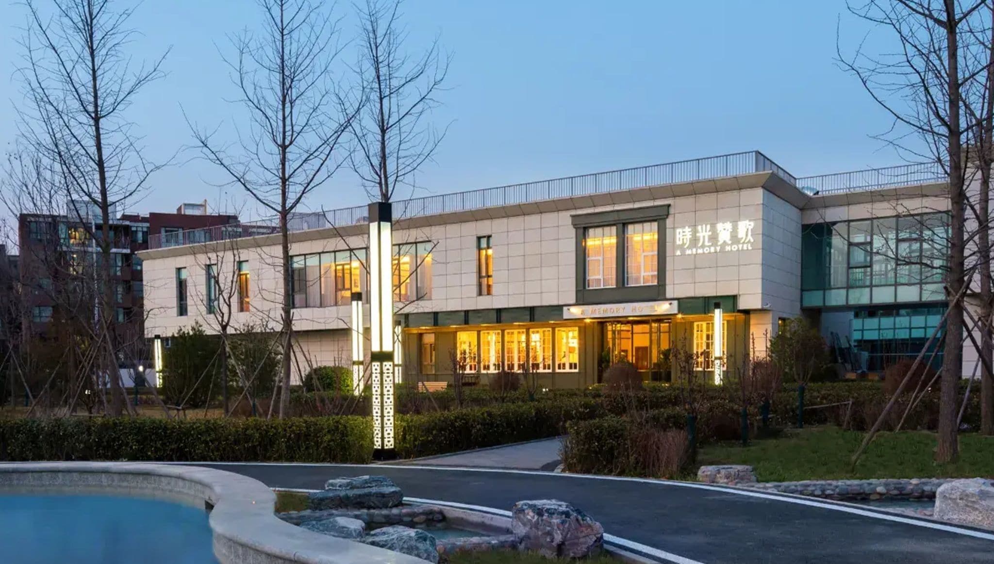 Un hôtel moderne doté d’un hall d’entrée bien éclairé, d’un espace piscine et d’un jardin aménagé.