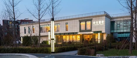 Un hôtel moderne doté d’un hall d’entrée bien éclairé, d’un espace piscine et d’un jardin aménagé.