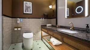 A modern bathroom with a toilet, sink, and mirror.