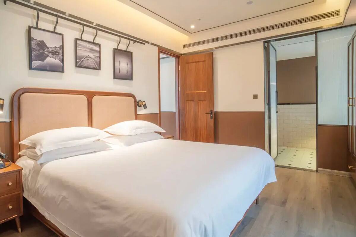 Habitación de hotel con cama, mesita de noche y armario.